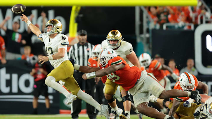 Aug 31, 2025; Miami Gardens, Florida, USA; Notre Dame Fighting Irish quarterback CJ Carr (13) throws the ball to avoid a sack against the Miami Hurricanes at Hard Rock Stadium. Mandatory Credit: Sam Navarro-Imagn Images
