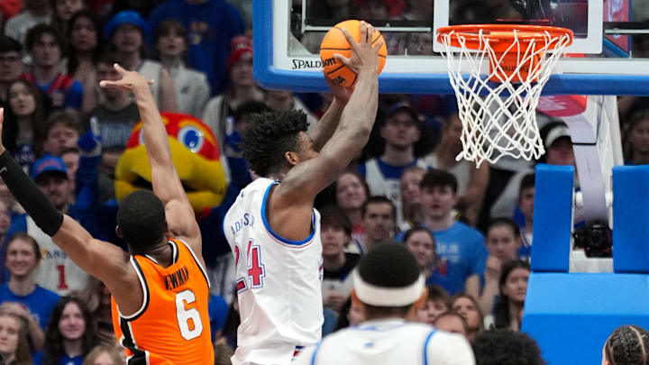 Feb 22, 2025; Lawrence, Kansas, USA; Kansas Jayhawks forward KJ Adams Jr. (24) dunks the ball as Oklahoma State Cowboys guard Brandon Newman (6) defends during the first half at Allen Fieldhouse. Mandatory Credit: Denny Medley-Imagn Images