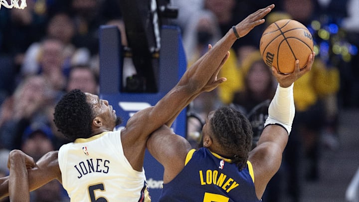 Apr 12, 2024; San Francisco, California, USA; Golden State Warriors forward Kevon Looney (5) shoots over New Orleans Pelicans forward Herbert Jones (5) during the first quarter at Chase Center.