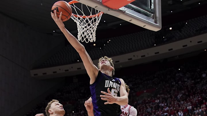 Jan 4, 2026; Bloomington, Indiana, USA; Washington Huskies forward Hannes Steinbach (6) scores past Indiana Hoosiers forward Tucker Devries (12) during the second half at Simon Skjodt Assembly Hall.