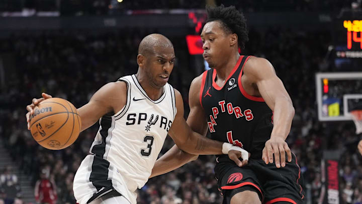 Mar 23, 2025; Toronto, Ontario, CAN; San Antonio Spurs guard Chris Paul (3) drives to the net against Toronto Raptors guard Scottie Barnes (4) during the second half at Scotiabank Arena. Mandatory Credit: John E. Sokolowski-Imagn Images