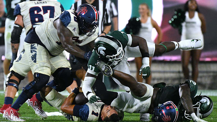 Aug 30, 2024; East Lansing, Michigan, USA;  Florida Atlantic Owls quarterback Cam Fancher (1) gets sacked by Michigan State Spartans defensive lineman Ken Talley (11) and Michigan State Spartans defensive lineman Khris Bogle (2) at Spartan Stadium. Mandatory Credit: Dale Young-Imagn Images