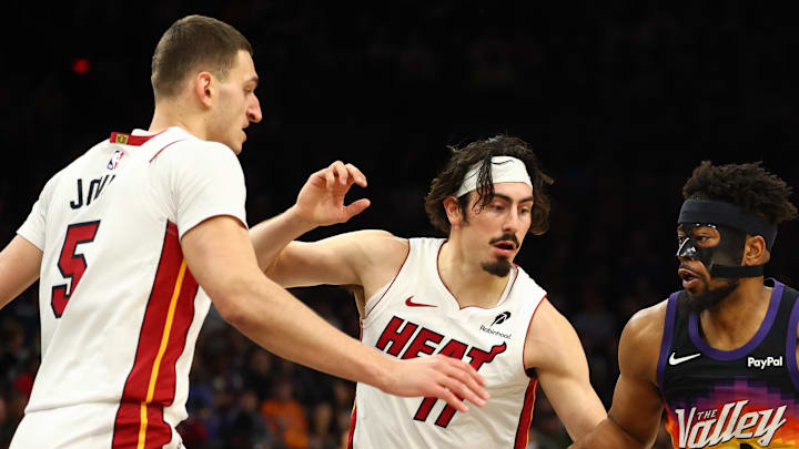 Jan 25, 2026; Phoenix, Arizona, USA; Phoenix Suns guard Jordan Goodwin (23) moves the ball against Miami Heat forward Jaime Jaquez Jr. (11) and Nikola Jovic (5) in the first half at Mortgage Matchup Center. Mandatory Credit: Mark J. Rebilas-Imagn Images