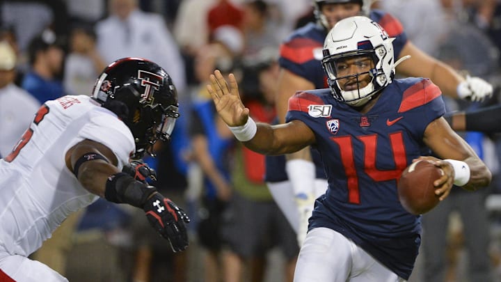 Sep 14, 2019; Tucson, AZ, USA; Arizona Wildcats quarterback Khalil Tate (14) runs the ball under pressure from Texas Tech Red Raiders linebacker Riko Jeffers (6) during the first half at Arizona Stadium. Mandatory Credit: Casey Sapio-Imagn Images
