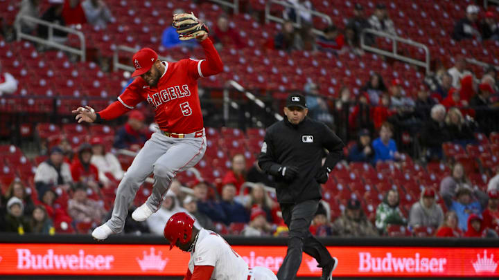 Apr 1, 2025; St. Louis, Missouri, USA; Los Angeles Angels third baseman Yoan Moncada (5) leaps over St. Louis Cardinals right fielder Jordan Walker (18) as he steals third base during the second inning at Busch Stadium.