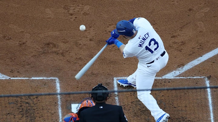 Oct 13, 2024; Los Angeles, California, USA; Los Angeles Dodgers third baseman Max Muncy (13) hits a two run single against the New York Mets in the first inning during game one of the NLCS for the 2024 MLB Playoffs at Dodger Stadium.