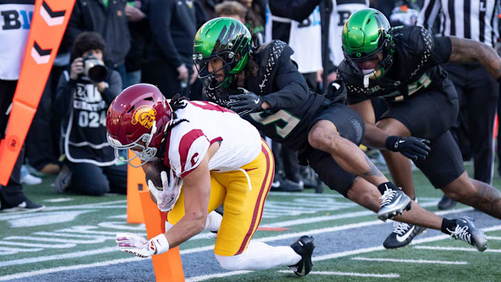 USC wide receiver Makai Lemon, left, dives into the corners of the end zone for a touchdown under cover from Oregon defensive back Theran Johnson