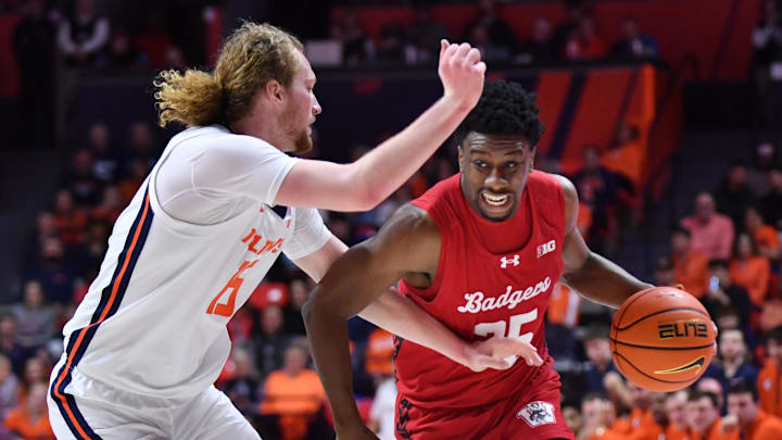 Feb 10, 2026; Champaign, Illinois, USA;  Wisconsin Badgers guard John Blackwell (25) drives the ball past Illinois Fighting Illini forward Jake Davis (15) during the second half at State Farm Center.