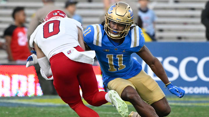 Nov 30, 2024; Pasadena, California, USA; UCLA Bruins defensive back Ramon Henderson (11) moves in to make the tackle on Fresno State Bulldogs wide receiver Mac Dalena (0) during the fourth quarter at Rose Bowl. Mandatory Credit: Robert Hanashiro-Imagn Images