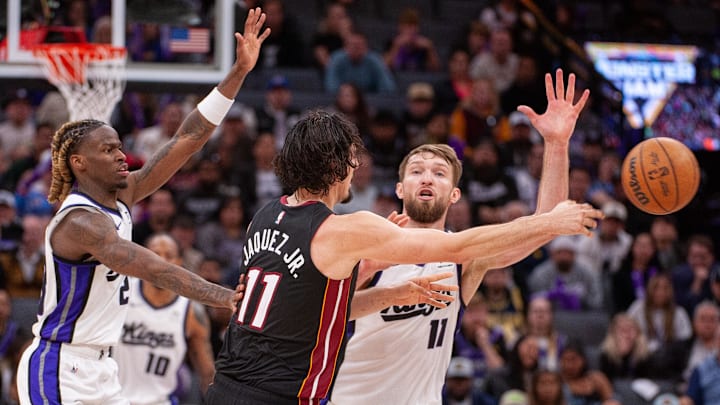 Jan 6, 2025; Sacramento, California, USA; Sacramento Kings guard Keon Ellis (23) and forward Domantas Sabonis (11) defend against Miami Heat guard Jaime Jaquez Jr. (11) during overtime at Golden 1 Center. Mandatory Credit: Ed Szczepanski-Imagn Images