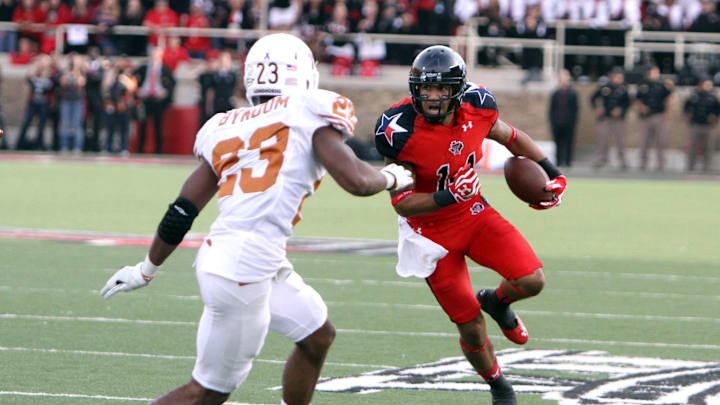 Nov 3, 2012; Lubbock, TX, USA; Texas Tech Red Raiders wide receiver Darrin Moore (14) rushes against Texas Longhorns corner back Carrington Byndom (23) in the second half at Jones AT&T Stadium.  Texas defeated Texas Tech 31-22. Mandatory Credit: Michael C. Johnson-Imagn Images
