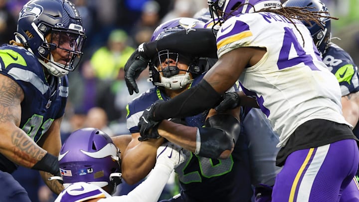Dec 22, 2024; Seattle, Washington, USA; Seattle Seahawks running back Zach Charbonnet (26) is gang tackled by the Minnesota Vikings during the fourth quarter at Lumen Field. Mandatory Credit: Joe Nicholson-Imagn Images