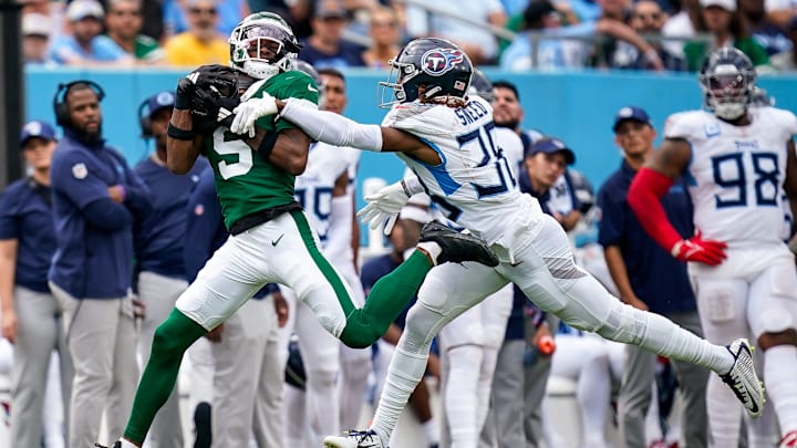New York Jets wide receiver Garrett Wilson (5) receives a pass past Tennessee Titans cornerback L'Jarius Sneed (38) during the fourth quarter at Nissan Stadium in Nashville, Tenn., Sunday, Sept. 15, 2024.