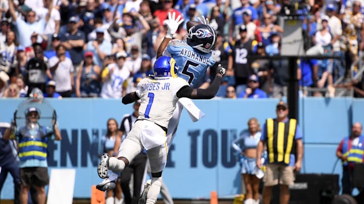 Sep 14, 2025; Nashville, Tennessee, USA; Tennessee Titans wide receiver Elic Ayomanor (5) makes a catch over Los Angeles Rams cornerback Emmanuel Forbes Jr. (1) during the first half at Nissan Stadium. Mandatory Credit: Steve Roberts-Imagn Images