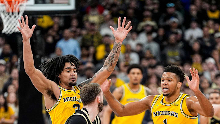 Michigan guard Elliot Cadeau (3) and guard Trey McKenney (1) defend Purdue guard Braden Smith (41) 