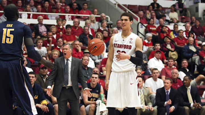 Jan 19, 2013; Stanford, CA, USA; Stanford Cardinal forward Dwight Powell (33) reacts after being fouled by California Golden Bears forward Bak Bak (15) as California Golden Bears head coach Mike Montgomery reacts in the background during the first half at Maples Pavilion. Mandatory Credit: Kelley L Cox-Imagn Images