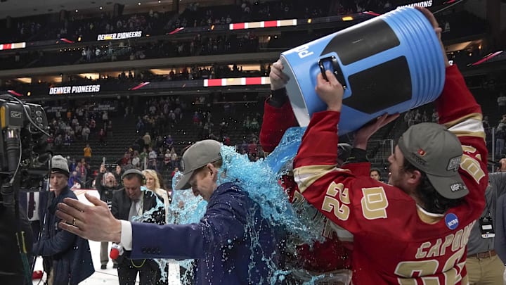 Apr 13, 2024; Saint Paul, Minnesota, USA; Denver Pioneers forward Connor Caponi (22) dumps blue Powerade on head coach David Carle after defeating the Boston College Eagles for the national championship at the 2024 Frozen Four college ice hockey tournament at Xcel Energy Center. Mandatory Credit: Nick Wosika-USA TODAY Sports
