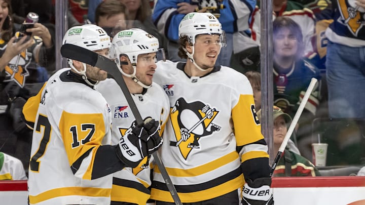 Mar 9, 2025; Saint Paul, Minnesota, USA;  Pittsburgh Penguins forward Sidney Crosby (87) celebrates his empty net goal with forward Bryan Rust (17) and forward Rickard Rakell (67) during the third period at Xcel Energy Center. Mandatory Credit: Nick Wosika-Imagn Images