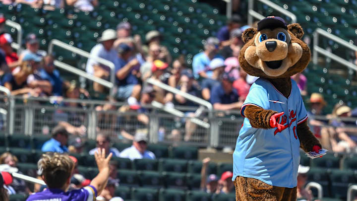 Jun 23, 2022; Minneapolis, Minnesota, USA;  Minnesota Twins mascot T.C. Bear throws a pack of baseball cards to a young fan during a game against the Cleveland Guardians at Target Field. Mandatory Credit: Nick Wosika-Imagn Images