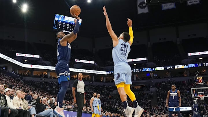 Minnesota Timberwolves guard Jaylen Nowell (4) hits a three-pointer as Memphis Grizzlies guard Tyus Jones (21) defends at Target Center. Minnesota Timberwolves guard Jaylen Nowell (4) hits a three-pointer as Memphis Grizzlies guard Tyus Jones (21) defends at Target Center.