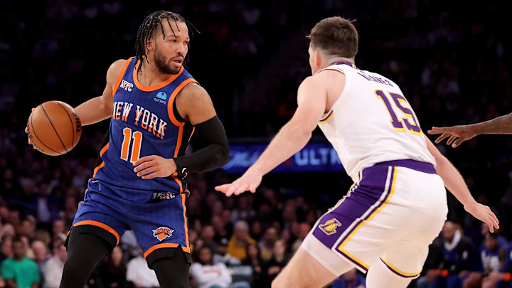 Feb 3, 2024; New York, New York, USA; New York Knicks guard Jalen Brunson (11) controls the ball against Los Angeles Lakers guard Austin Reaves (15) during the fourth quarter at Madison Square Garden. Mandatory Credit: Brad Penner-Imagn Images