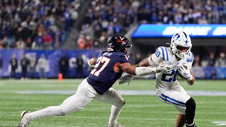 Dec 6, 2025; Charlotte, N.C.; Duke Blue Devils running back Nate Sheppard (20) runs the ball while defended by Virginia Cavaliers safety Devin Neal Jr. (27) during the second half during the 2025 ACC Championship game at Bank of America Stadium. Mandatory Credit: Jim Dedmon-Imagn Images Dec 6, 2025; Charlotte, N.C.; Duke Blue Devils running back Nate Sheppard (20) runs the ball while defended by Virginia Cavaliers safety Devin Neal Jr. (27) during the second half during the 2025 ACC Championship game at Bank of America Stadium. Mandatory Credit: Jim Dedmon-Imagn Images