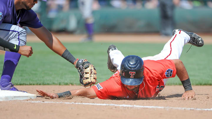 Jun 19, 2016; Omaha, NE, USA; TCU Horned Frogs infielder Michael Landestoy (13) tags out Texas Tech Red Raiders infielder Eric Gutierrez (12) on a pick off in the fourth inning in the 2016 College World Series at TD Ameritrade Park. Mandatory Credit: Steven Branscombe-Imagn Images