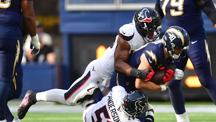 Dec 27, 2025; Inglewood, California, USA;  Los Angeles Chargers quarterback Justin Herbert (10) is sacked by Houston Texans defensive end Danielle Hunter (55) and defensive end Will Anderson Jr. (51) during the first half at SoFi Stadium. Mandatory Credit: Gary A. Vasquez-Imagn Images