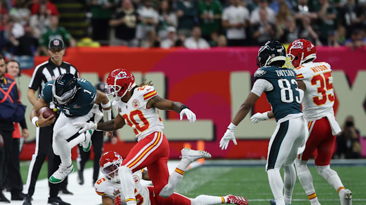 Feb 9, 2025; New Orleans, LA, USA; Philadelphia Eagles quarterback Jalen Hurts (1) leaps out of bounds while runs with the ball as Kansas City Chiefs safety Bryan Cook (6) and Chiefs safety Justin Reid (20) chase during Super Bowl LIX at Caesars Superdome. Mandatory Credit: Geoff Burke-Imagn Images