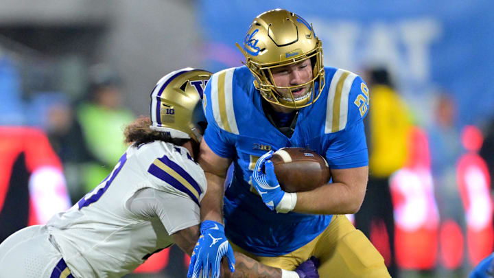 Nov 22, 2025; Pasadena, California, USA;  UCLA Bruins tight end Jack Pedersen (28) hangs on to the ball before he is forced out of bounds by Washington Huskies linebacker Xe'Ree Alexander (10) during the first half at the Rose Bowl. Mandatory Credit: Jayne Kamin-Oncea-Imagn Images