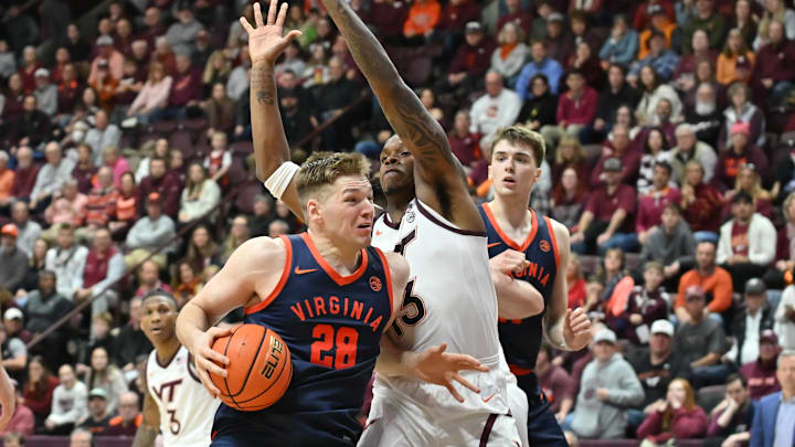 Dec 31, 2025; Blacksburg, Virginia, USA;  Virginia Cavaliers forward Thijs de Ridder (28) makes a move toward the basket as Virginia Tech Hokies forward Amani Hansberry (13) defends during the first overtime period at Cassell Coliseum. Mandatory Credit: Brian Bishop-Imagn Images
