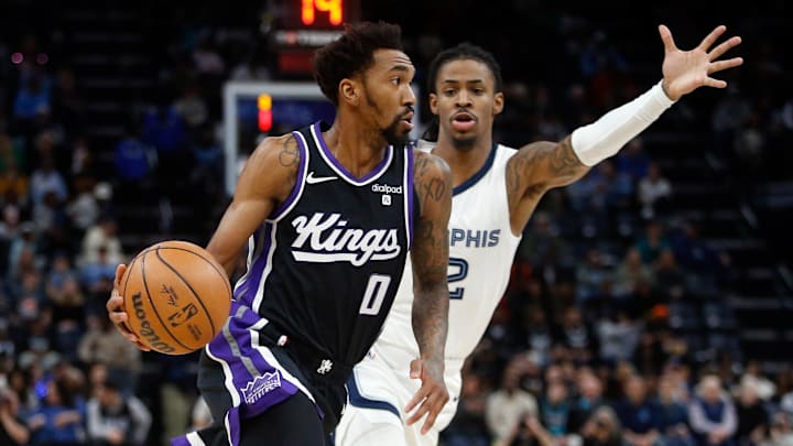 Dec 31, 2023; Memphis, Tennessee, USA; Sacramento Kings guard Malik Monk (0) drives to the basket as Memphis Grizzlies guard Ja Morant (12) defends during the first half at FedExForum. Mandatory Credit: Petre Thomas-Imagn Images