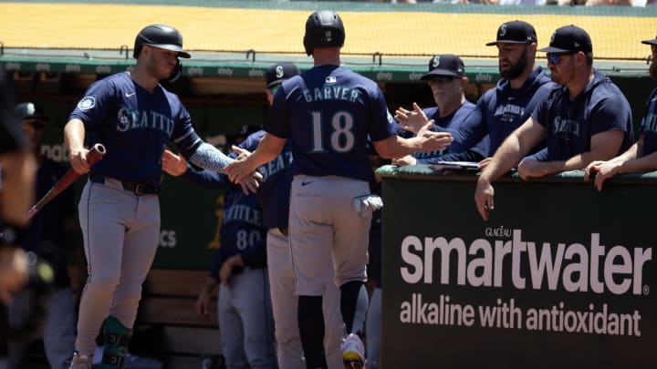 Seattle Mariners designated hitter Mitch Garver (18) is greeted by his teammates after he scored on a sacrifice fly against the Oakland Athletics during the third inning at Oakland-Alameda County Coliseum on June 6.