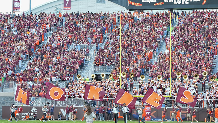 Nov 9, 2024; Blacksburg, Virginia, USA;   The Virginia Tech Hokies cheerleads carry flags that spell Hokies after a touchdown during the first quarter at Lane Stadium. Mandatory Credit: Brian Bishop-Imagn Images