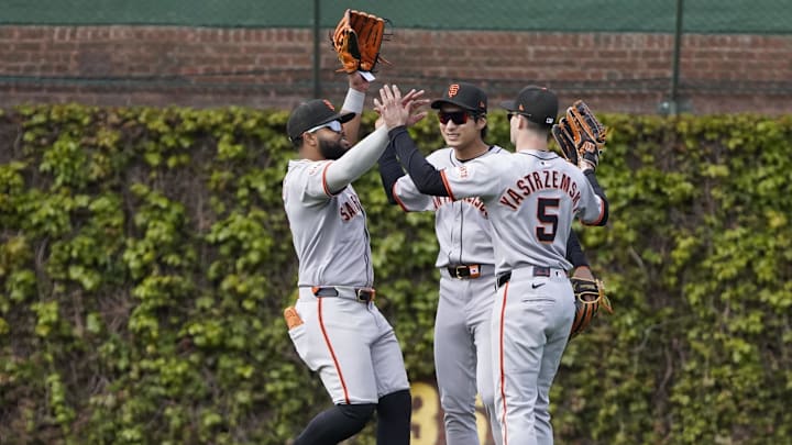 May 7, 2025; Chicago, Illinois, USA; (L-R San Francisco Giants outfielder Heliot Ramos (17) outfielder Jung Hoo Lee (51) and  outfielder Mike Yastrzemski (5) celebrate their win against the Chicago Cubs at Wrigley Field.