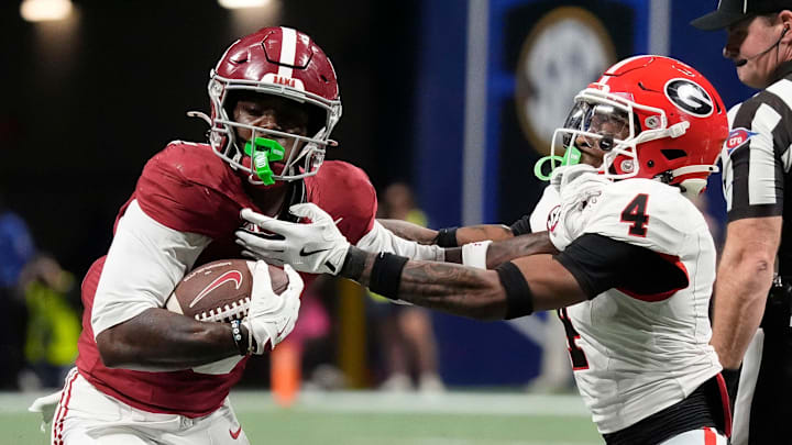 Former Alabama wide receiver Germie Bernard (5) uses a stiff arm to break a tackle by Georgia defensive back KJ Bolden (4) at Mercedes-Benz Stadium. 