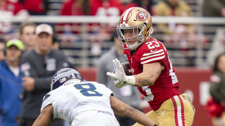 November 17, 2024; Santa Clara, California, USA; San Francisco 49ers running back Christian McCaffrey (23) runs against Seattle Seahawks cornerback Coby Bryant (8) during the second quarter at Levi's Stadium. Mandatory Credit: Kyle Terada-Imagn Images