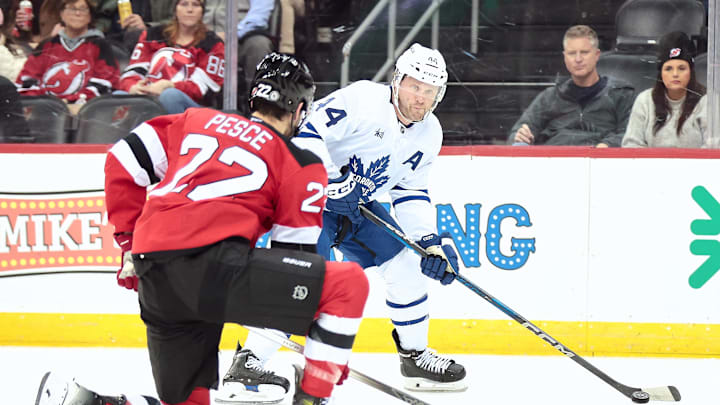 Dec 10, 2024; Newark, New Jersey, USA; Toronto Maple Leafs defenseman Morgan Rielly (44) passes the puck against New Jersey Devils defenseman Brett Pesce (22) during the first period at Prudential Center. Mandatory Credit: Luther Schlaifer-Imagn Images