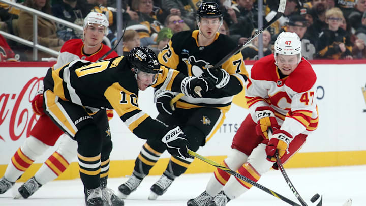 Nov 30, 2024; Pittsburgh, Pennsylvania, USA;  Calgary Flames center Connor Zary (47) moves the puck against Pittsburgh Penguins left wing Drew O'Connor (10) during the third period at PPG Paints Arena. Mandatory Credit: Charles LeClaire-Imagn Images