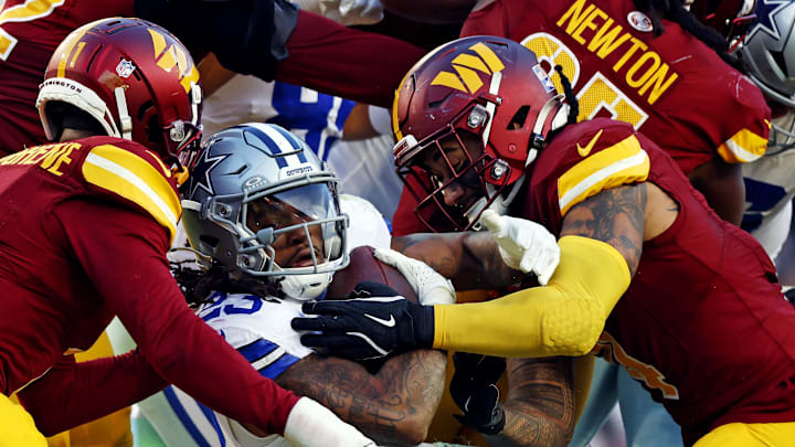 Nov 24, 2024; Landover, Maryland, USA; Dallas Cowboys running back Rico Dowdle (23) runs the ball against Washington Commanders cornerback Noah Igbinoghene (1) during the fourth quarter at Northwest Stadium. Mandatory Credit: Peter Casey-Imagn Images
