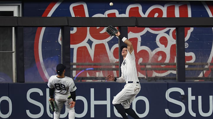 Sep 26, 2024; Bronx, New York, USA; New York Yankees center fielder Aaron Judge (99) makes a catch for an out in front of left fielder Jasson Dominguez (89) during the first inning against the Baltimore Orioles at Yankee Stadium. Mandatory Credit: Vincent Carchietta-Imagn Images