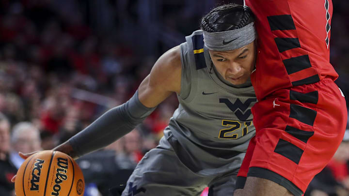 Mar 9, 2024; Cincinnati, Ohio, USA; West Virginia Mountaineers guard RaeQuan Battle (21) dribbles against the Cincinnati Bearcats in the second half at Fifth Third Arena. Mandatory Credit: Katie Stratman-Imagn Images
