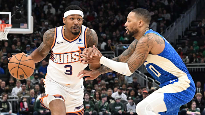 Mar 17, 2024; Milwaukee, Wisconsin, USA; Phoenix Suns guard Bradley Beal (3) drives against Milwaukee Bucks guard Damian Lillard (0) on the second half at Fiserv Forum. Mandatory Credit: Michael McLoone-Imagn Images