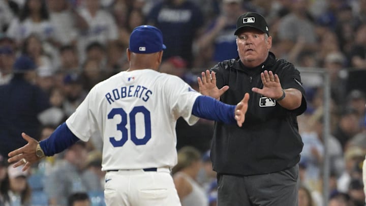 Aug 7, 2024; Los Angeles, California, USA;  Los Angeles Dodgers manager Dave Roberts (30) is ejected by umpire Hunter Wendelstedt (21) after arguing an interference call by Los Angeles Dodgers shortstop Miguel Rojas (11) in the sixth inning against the Philadelphia Phillies at Dodger Stadium. Mandatory Credit: Jayne Kamin-Oncea-USA TODAY Sports
