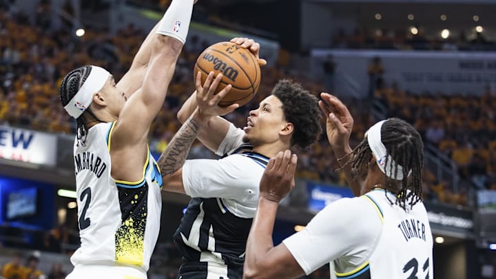 Apr 19, 2025; Indianapolis, Indiana, USA;  Milwaukee Bucks guard Ryan Rollins (13) shoots the ball while  Indiana Pacers guard Andrew Nembhard (2) defends in the first half at Gainbridge Fieldhouse. Mandatory Credit: Trevor Ruszkowski-Imagn Images