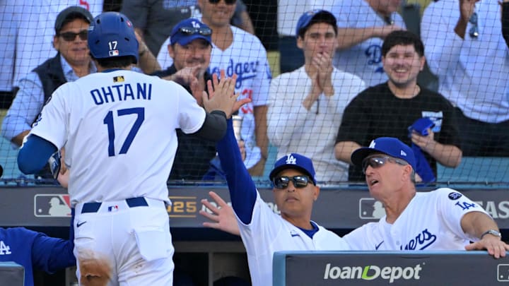 Oct 16, 2025; Los Angeles, California, USA; Los Angeles Dodgers designated hitter player Shohei Ohtani (17) is greeted at the dugout by manager Dave Roberts (30) after scoring a run in the first inning of game three of the NLCS during the 2025 MLB playoffs against the Milwaukee Brewers at Dodger Stadium. Mandatory Credit: Jayne Kamin-Oncea-Imagn Images