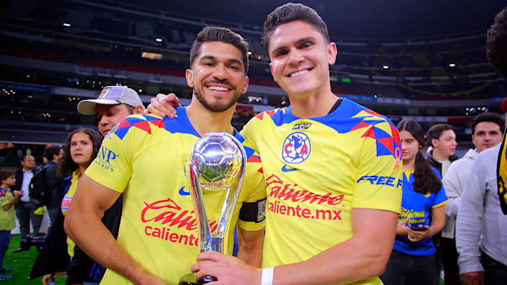 Henry Martín e Israel Reyes sostienen el trofeo de la Liga MX.