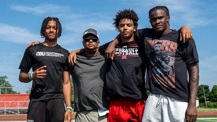 From left to right, Donald Tabron II, 16, Donovan Dooley, 40, owner and founder of Quarterback University, Trae Taylor, 16, and Bryce Underwood, 17, take a photo together after participating in a private workout in Detroit on Saturday, June 21, 2025.