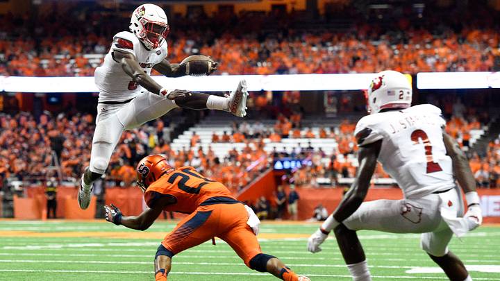 Sep 9, 2016; Syracuse, NY, USA; Louisville Cardinals quarterback Lamar Jackson (8) leaps over Syracuse Orange defensive back Cordell Hudson (20) while running with the ball during the second quarter at the Carrier Dome. Mandatory Credit: Rich Barnes-USA TODAY Sports