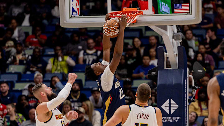 Nov 19, 2025; New Orleans, Louisiana, USA;  New Orleans Pelicans center Derik Queen (22) dunks the ball against Denver Nuggets center Nikola Jokić (15) and center Jonas Valančiūnas (17) during the first half  at Smoothie King Center. Mandatory Credit: Stephen Lew-Imagn Images